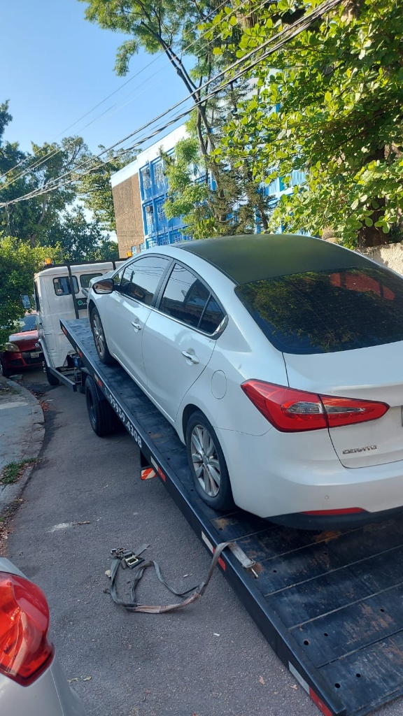 Carro sedan branco sendo rebocado pelo guincho RS em Jacarepaguá.