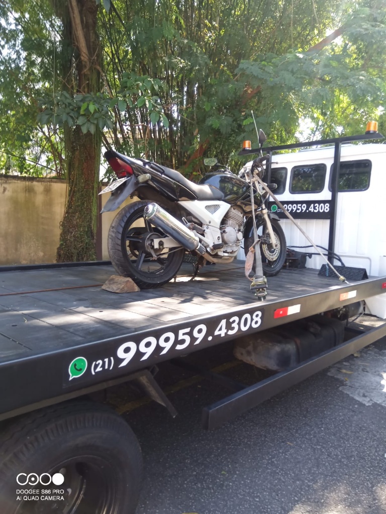 Reboque de motocicleta na plataforma do guincho, destacando o cuidado.